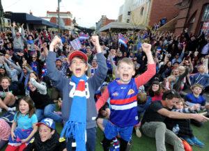 Western Bulldogs fans watching on a big screen outside the Sun Theatre in Yarraville celebrate their team's win over Sydney Swans in the AFL Grand Final. Picture: Andrew Henshaw